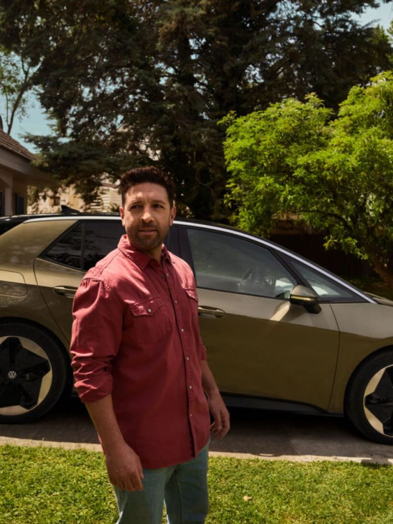 Un hombre de pie frente a un Volkswagen ID.3 aparcado en casa