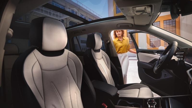 Mujer abriendo la puerta de un Volkswagen Tiguan vista desde el interior