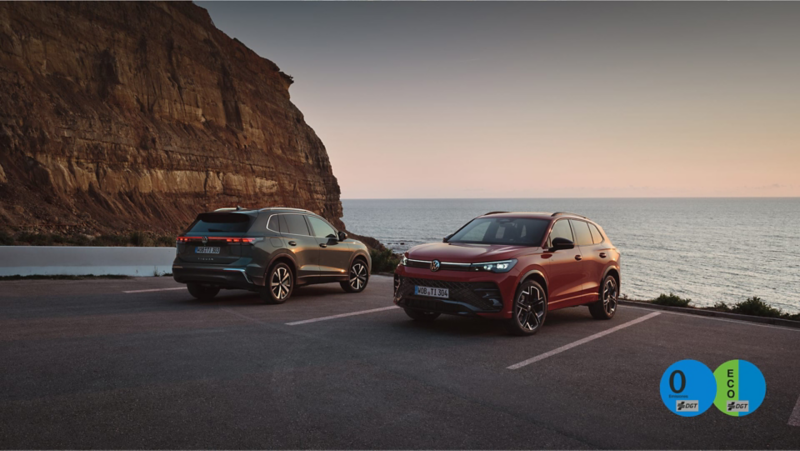 Dos Volkswagen estacionados en una plaza de estacionamiento al lado del mar