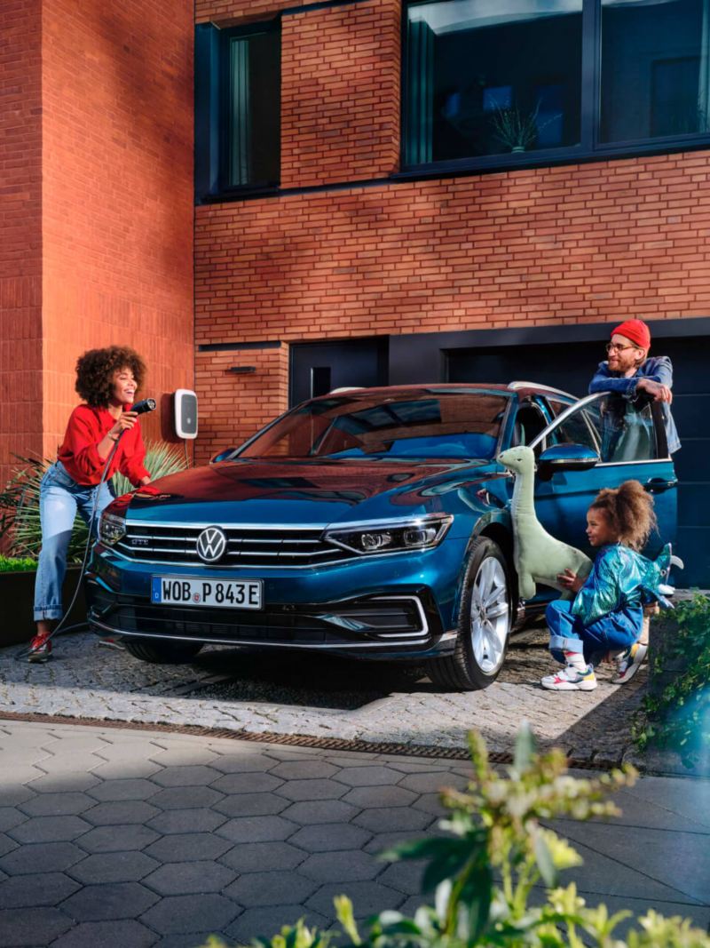 Familia mostrando cómo van a cargar su Volkswagen Passant Variant híbrido enchufable.