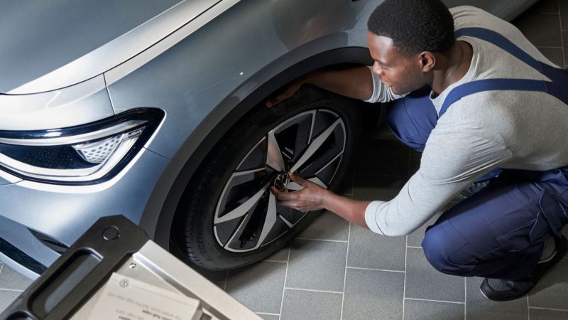 Un agente de servicio Volkswagen reparando una rueda de un Volkswagen