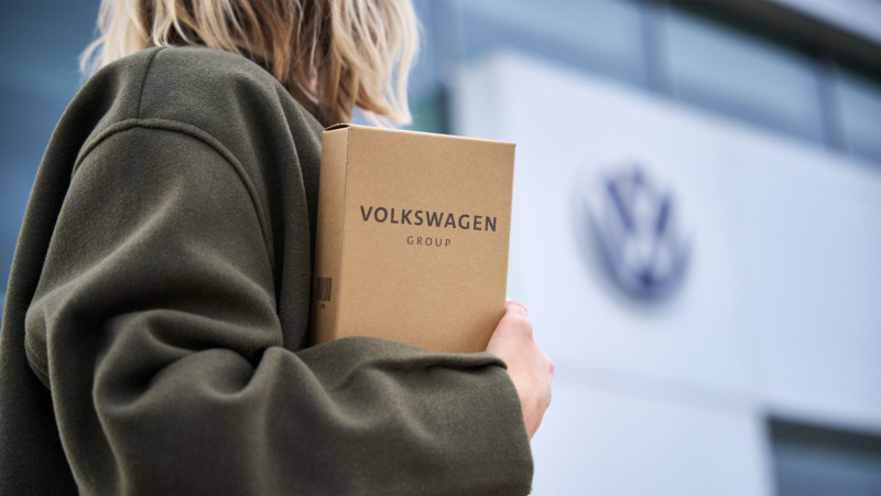 Una mujer sujetando un paquete de Volkswagen