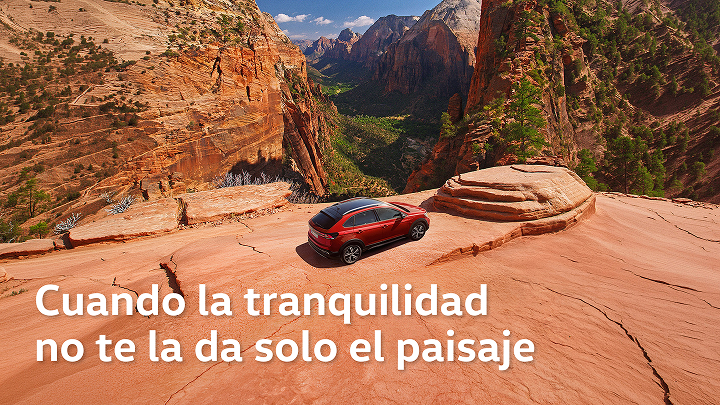 Un Volkswagen Tiguan rojo junto a un barranco semidesértico