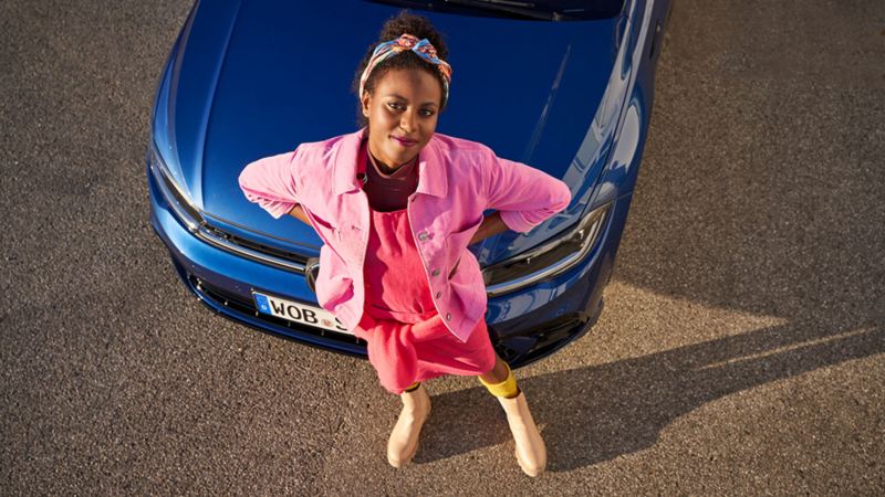Chica de pie delante de su VW azul