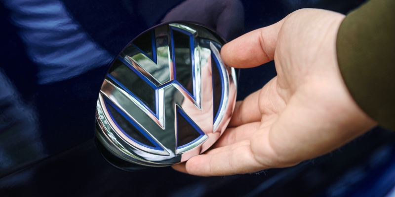 Primer plano  de una mano en el logotipo de Volkswagen