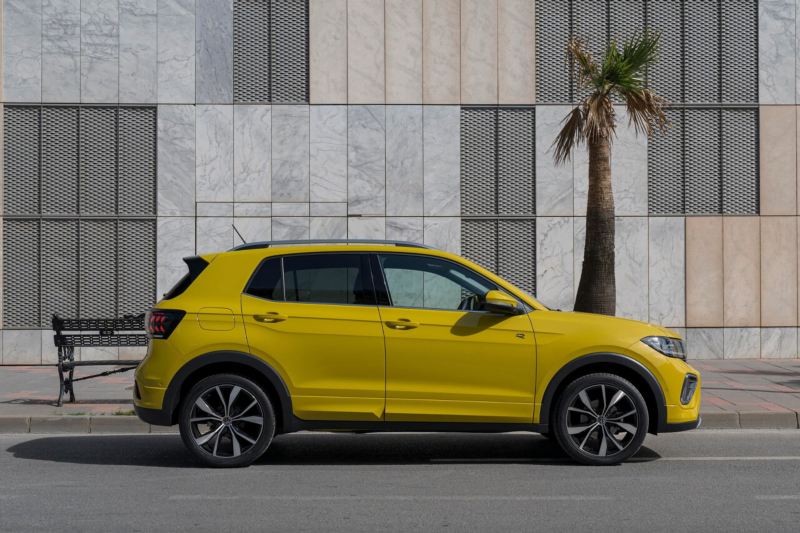 Un Volkswagen T-Cross seminuevo vista lateral de color amarillo estacionado en la calle