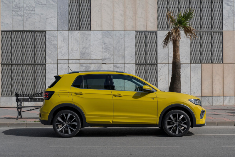 Un Volkswagen T-Cross seminuevo vista lateral de color amarillo estacionado en la calle