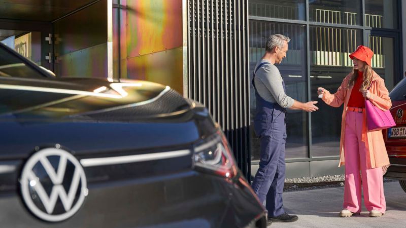 Un agente de servicio Volkswagen recibe las llaves de un modelos ID. de una clienta
