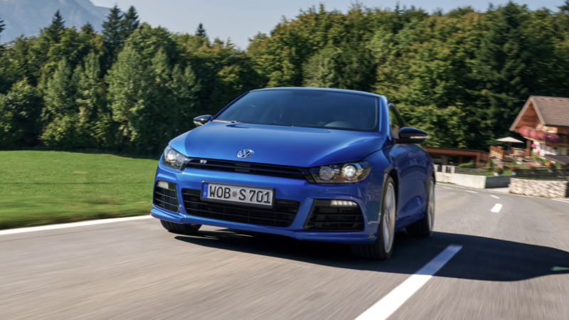 Volkswagen Sirocco azul circulando por una carretera de montaña