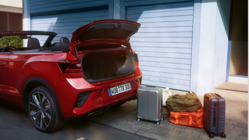 T-Roc Cabriolet rojo con el maletero abierto y maletas en la acera