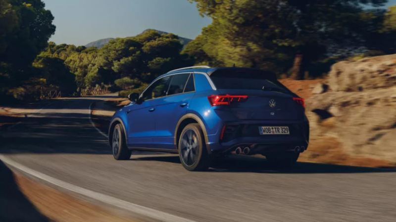 Un Volkswagen T-Roc R azul visto desde atrás en una carretera de montaña