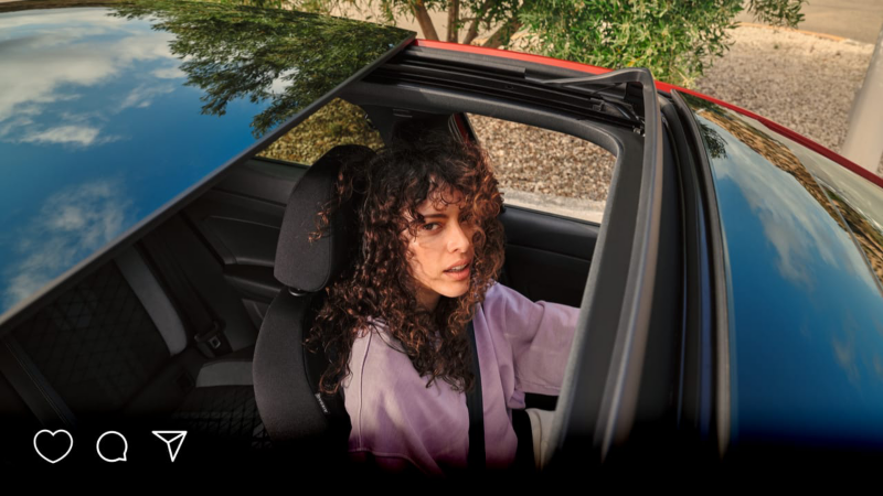 Una chica dentro de un Volkswagen Taigo vista desde arriba a través del techo solar panorámico