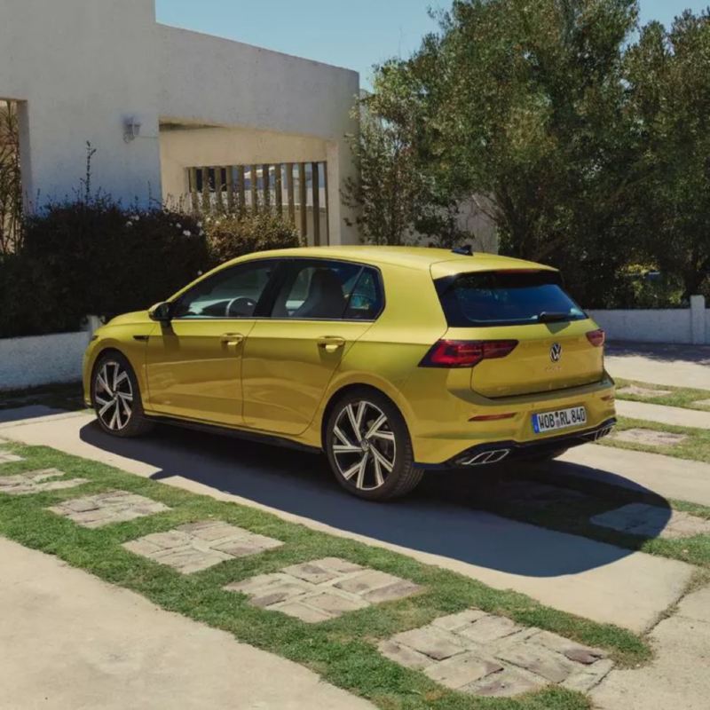 Volkswagen Golf 8 amarillo aparcado frente a una casa
