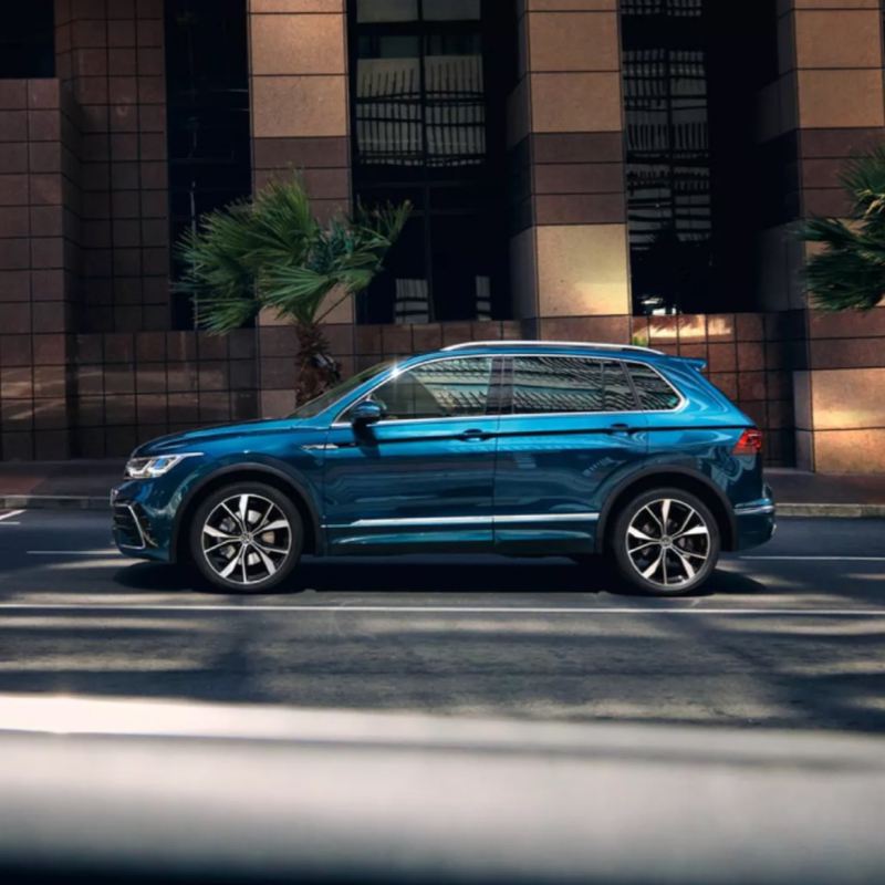 Nuevo Volkswagen Tiguan azul visto de costado aparcado en la calle