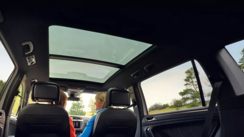 Vista interior trasera de un Volkswagen Tiguan Allspace con dos personas en su interior