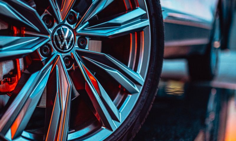 Detalle de una llanta de un Volkswagen Tiguan reflejando luces rojas y azules