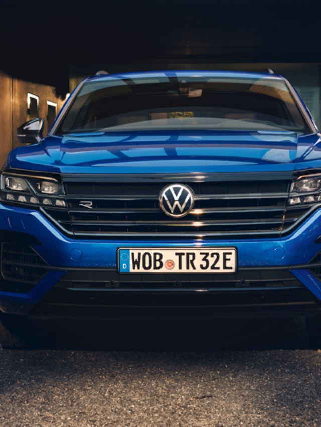 Volkswagen Touareg azul visto de frente aparcado en una casa