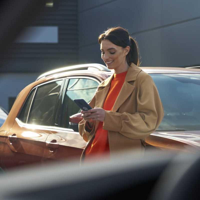 Chica entra el brazo por el techo panorámico de su Volkswagen
