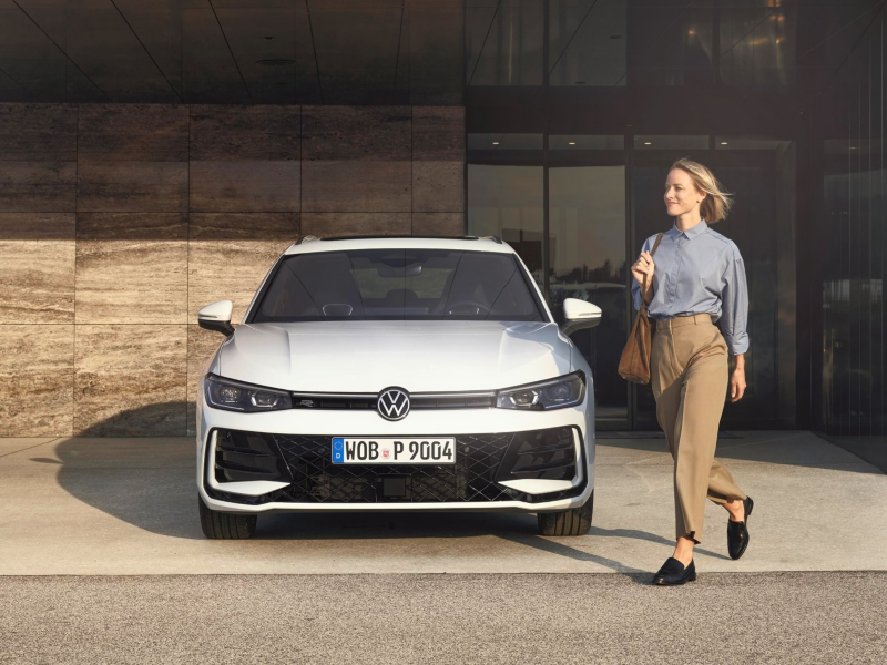 Una mujer camina al lado de un Volkswagen