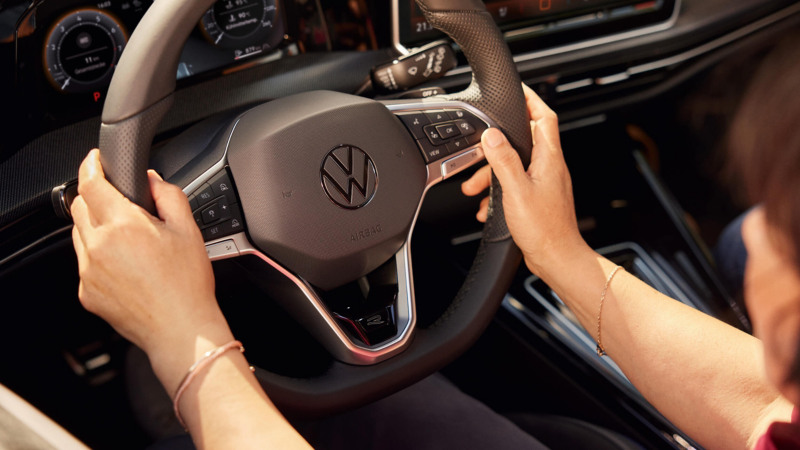 A close-up of someone with their hands on the steering wheel