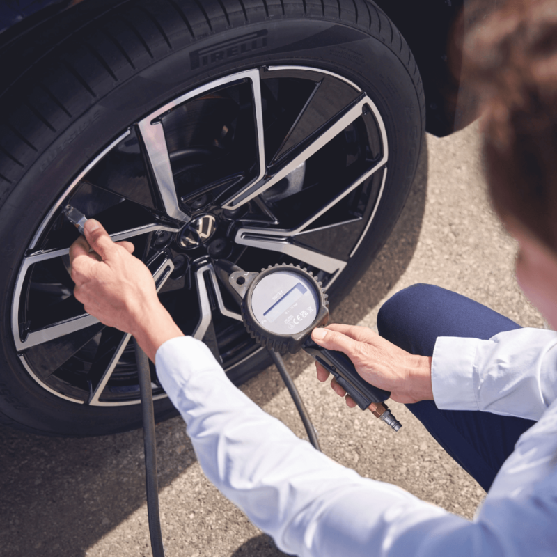 człowiek pompuje oponę kompresorem