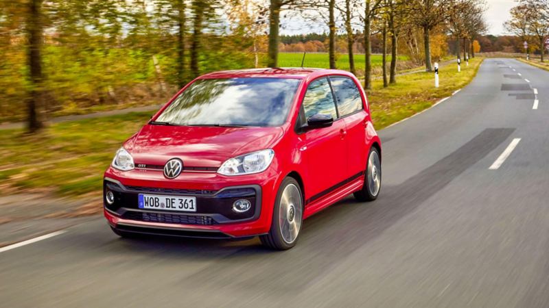 Vue de 3/4 avant d'une VW up! GTI roulant sur une route.