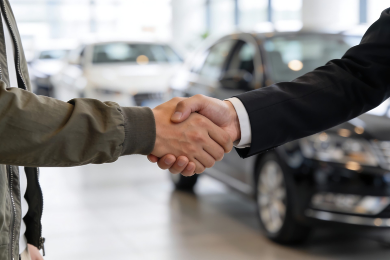 Uścisk dłoni po podpisaniu umowy finansowania nowego Volkswagena z salonu