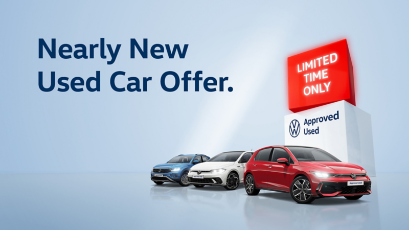 Three VW cars in front of an Approved Used Sale banner
