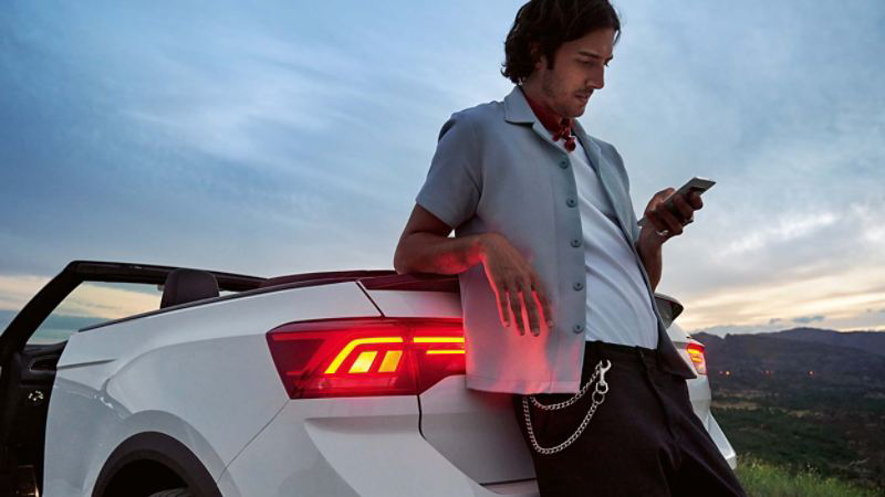 Man leaning against the boot of a white T-Roc Cabriolet