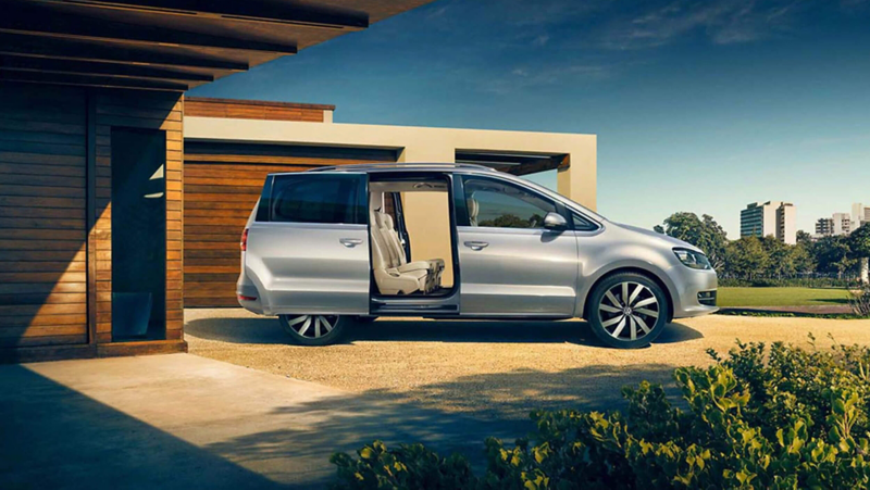 A VW Sharan parked in a driveway with opened side doors