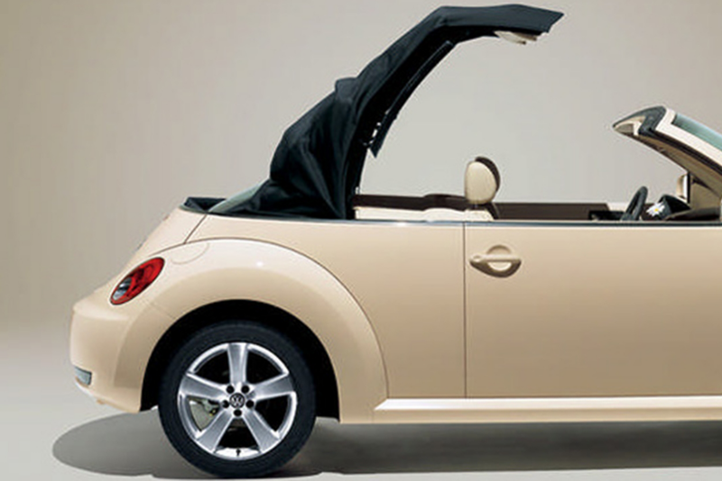 Profile shot of a cream Volkswagen Beetle Cabriolet, the roof opening.
