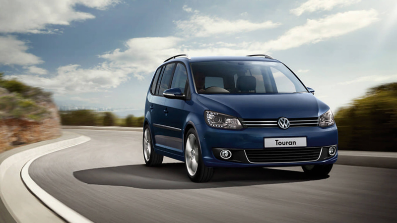 A blue Touran car driving on the road 