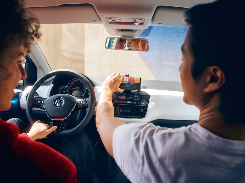 Two people in the front seats of a Volkswagen up!