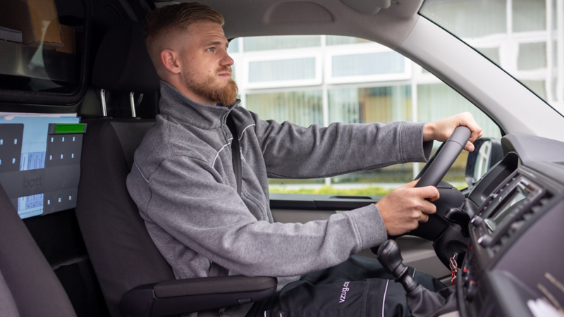 Servicetechniker von V-Zug sitzt hinter dem Steuer von VW Transporter