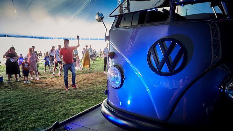A blue Volkswagen campervan with people standing by