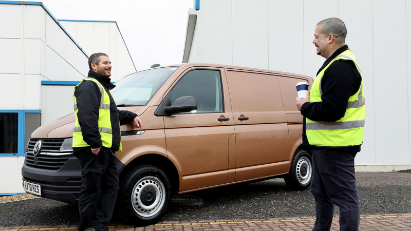 Two van drivers standing next to a VW Van.