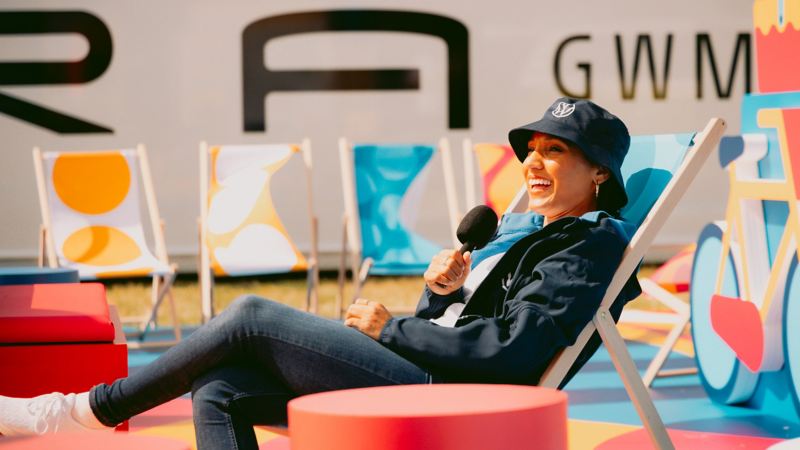 Photo showing an event host sitting on a deck chair. 