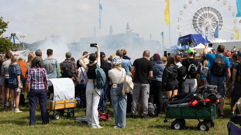 Photo showing a group of attendees at CarFest 2024 watching a display. 