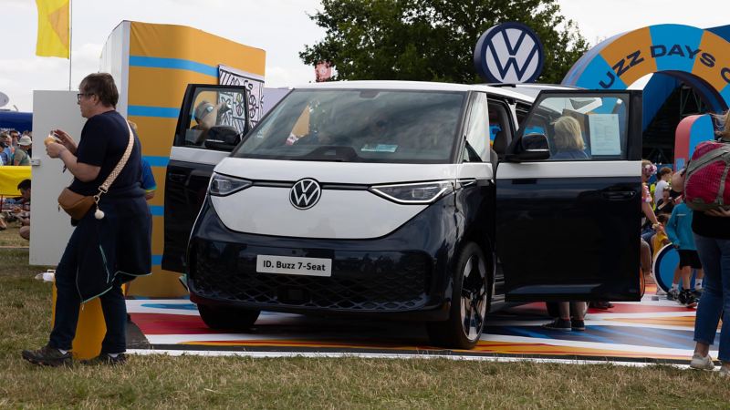 Photo showing an ID. Buzz on display with attendances walking around it at CarFest 2024.