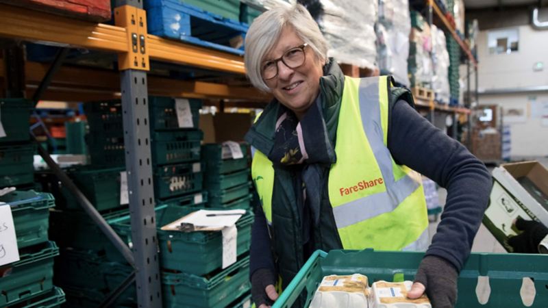 An employee of FareShare with a crate of food