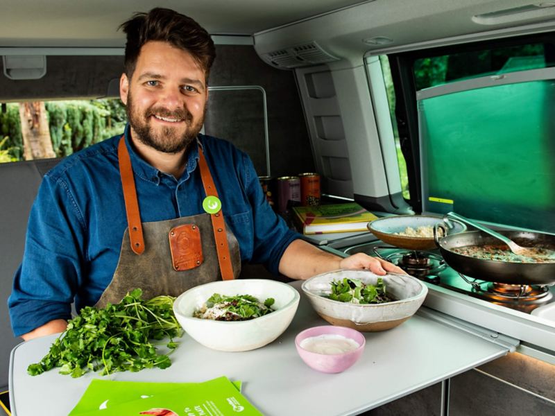 Chef Tom sitting inside a California camper van with some ingredients