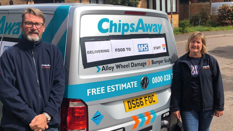 Photo showing the owners of Chips Away standing next to a VW van.