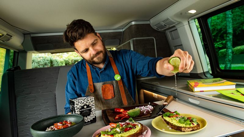 A man preparing food inside a Volkswagen California.