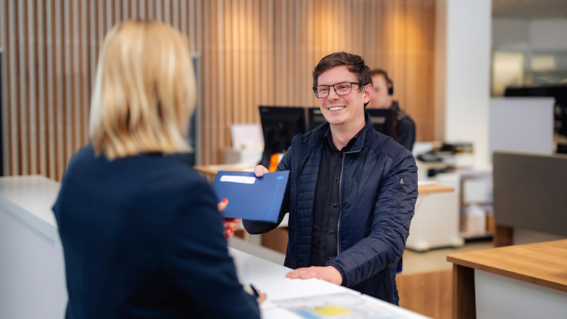 Mand og kvinde taler ved en desk