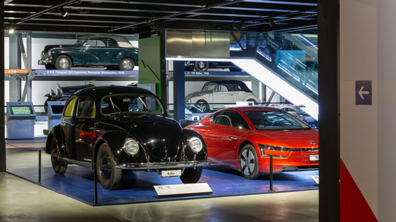 Ein VW Käfer und ein VW XL1 stehen nebeneinander
