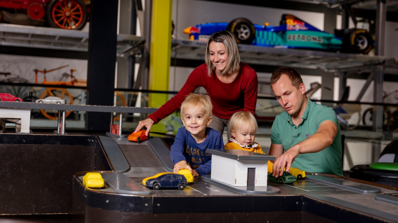 Eine Familie, welche mit alten Autos spielt