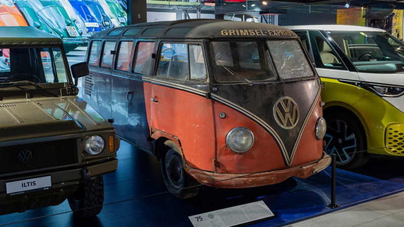Ein rot-blauer VW Bulli zwischen den anderen Modellen