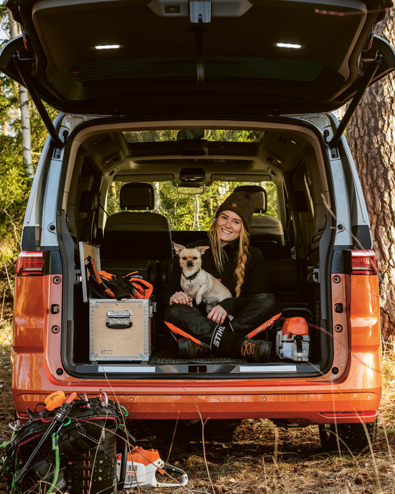 Victoria Carstens bak i en VW Multivan eHybrid minibuss med hunden Stanley i knät