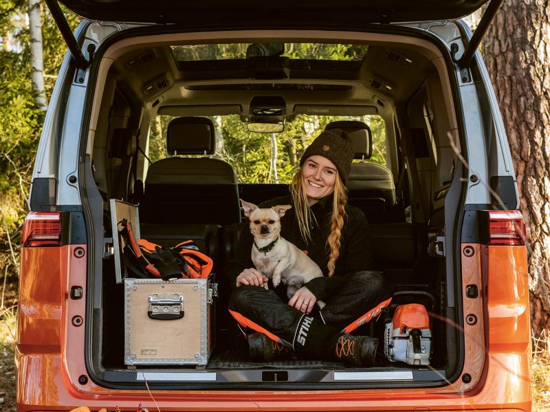 Victoria Carstens bak i en VW Multivan eHybrid minibuss med hunden Stanley i knät