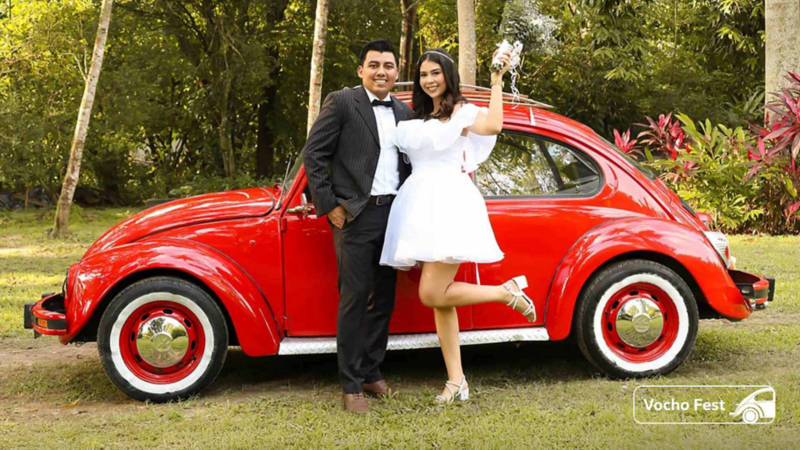 Pareja de recién casados con Vochito de color rojo.